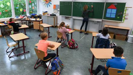 Schülerinnen und Schüler der Klasse 4c der Robert-Schumann-Grundschule sitzen mit Abstand zueinander im Unterricht.