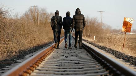 Migranten laufen  in der Nähe des Evros-Flusses an der griechisch-türkischen Grenze auf Bahngleisen. 