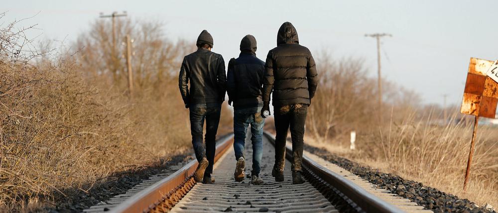 Migranten laufen  in der Nähe des Evros-Flusses an der griechisch-türkischen Grenze auf Bahngleisen. 