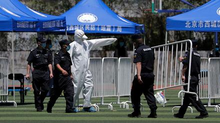 Peking: Ein Arbeiter leitet Sicherheitskräfte an, während sie Barrikaden für die Durchführung von Nukleinsäuretests in einem Stadion aufbauen.