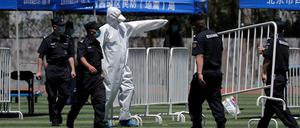 Peking: Ein Arbeiter leitet Sicherheitskräfte an, während sie Barrikaden für die Durchführung von Nukleinsäuretests in einem Stadion aufbauen.