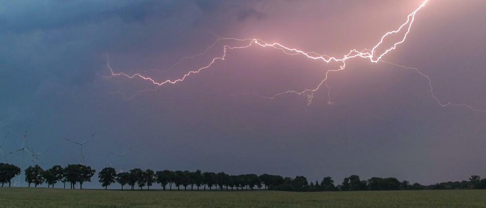 Ein Blitz erhellt am Samstag den Abendhimmel über der Landschaft im Landkreis Oder-Spree in Brandenburg.