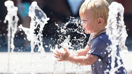 Ein Zweijähriger planscht im Juli 2019 bei Temperaturen nahe 40 Grad Celsius in einem städtischenBrunnen. In Innenstädten machen sich Hitzewellen und Rekordtemperaturen besonders stark bemerkbar.
