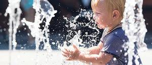 Ein Zweijähriger planscht im Juli 2019 bei Temperaturen nahe 40 Grad Celsius in einem städtischenBrunnen. In Innenstädten machen sich Hitzewellen und Rekordtemperaturen besonders stark bemerkbar. 