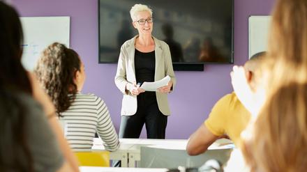 Eine Dozentin steht in einem Seminar vor Studierenden.