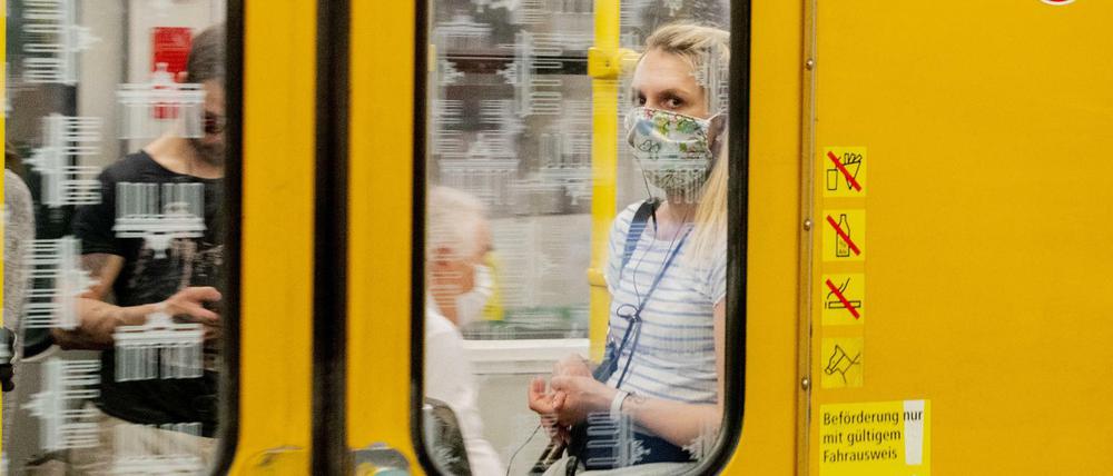 Eine Frau mit Mundschutz ist im U-Bahnhof Turmstraße in einer U-Bahn zu sehen. In Berlin gilt im öffentlichen Nahverkehr zur Eindämmung des Coronavirus die Pflicht für das Tragen einer Bedeckung von Mund und Nase.