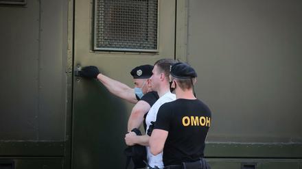 Polizeibeamte halten einen Demonstranten während einer Kundgebung fest.