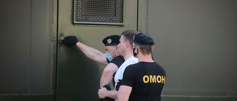 Polizeibeamte halten einen Demonstranten während einer Kundgebung fest.