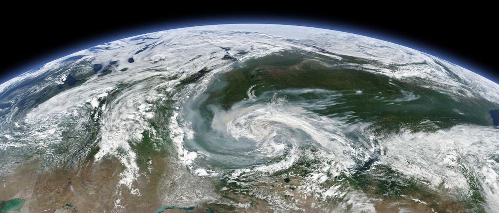 Russland, Krasnojarsk: Rauchschwaden, die sich mit einem größeren Sturmsystem vermischen - am Nordpolarkreis lodern wieder Wald- und Flächenbrände. 