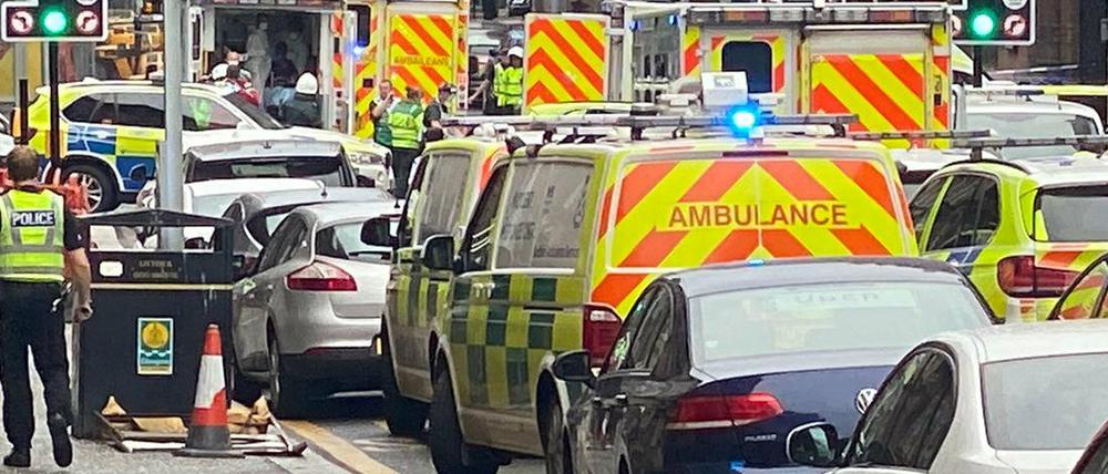 Rettungs- und Polizeifahrzeuge stehen nahe des Tatorts in Glasgow.