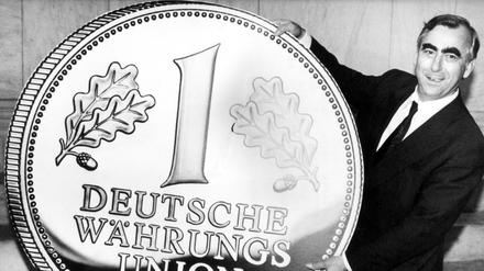So groß ist die D-Mark: Bundesfinanzminister mit übergroßer Gedenkmünze kurz vor der Währungsunion Ende Juni in Ost-Berlin. 