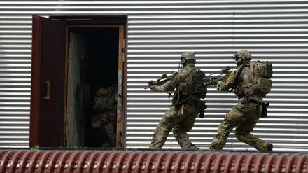 Soldaten des Kommandos Spezialkräfte (KSK) stürmen auf dem Kasernengelände während einer Übung in eine Tür. 