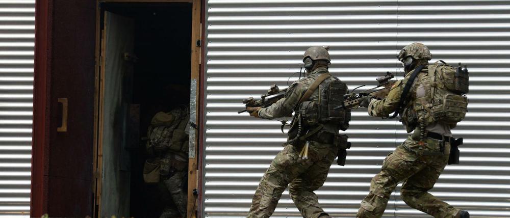 Soldaten des Kommandos Spezialkräfte (KSK) stürmen auf dem Kasernengelände während einer Übung in eine Tür. 