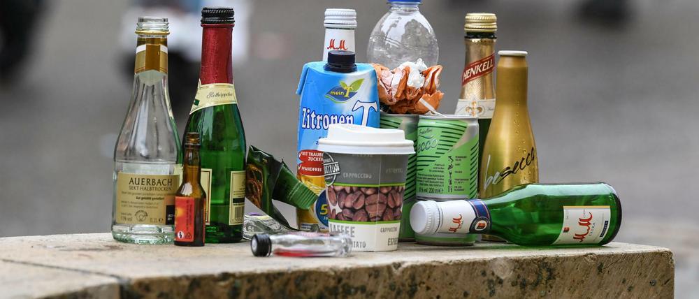 Leere Flaschen diverser alkoholischer Getränke stehen nach einer langen Nacht auf einer Mauer.