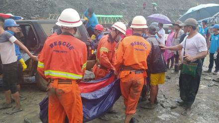 Rettungshelfer tragen Verletzte und Leichen aus den Trümmern.