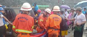 Rettungshelfer tragen Verletzte und Leichen aus den Trümmern.