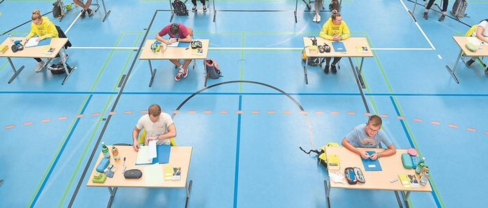 Geprüft. Abitur in Coronazeiten in der Sporthalle eines Gymnasiums in Ravensburg. Die rein taktische Wahl von Leistungskursen – um den besten Punkteschnitt zu erreichen – ist eine Sache, die künftig anders werden sollte, sagen Hurrelmann und Dohmen. Foto: Felix Kästle/dpa