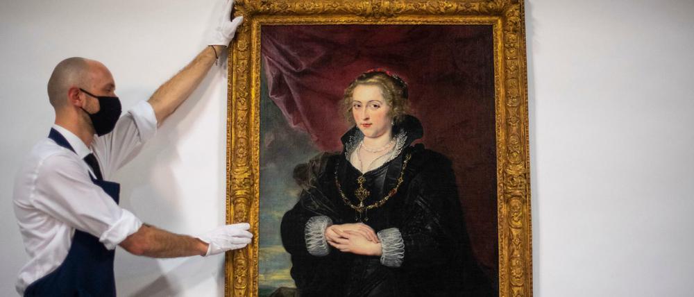 Ein Mitarbeiter des Auktionshauses Sotheby's mit einem Frauenporträt, das jetzt Peter Paul Rubens zugeschrieben wird.