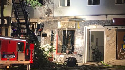 Ein Feuerwehrauto steht am Einsatzort vor dem Imbiss.