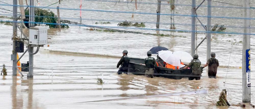 Rettungskräfte retten Anwohner aus einer überschwemmten Gegend.