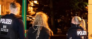 Polizisten führen in der Jessnerstraße eine Person ab. Unbekannte randalierten am Samstagabend in Friedrichshain.