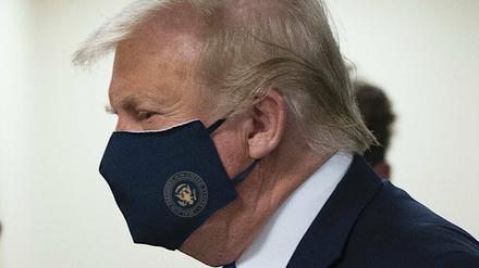 Donald Trump trägt eine Maske mit dem Siegel des US-Präsidenten.