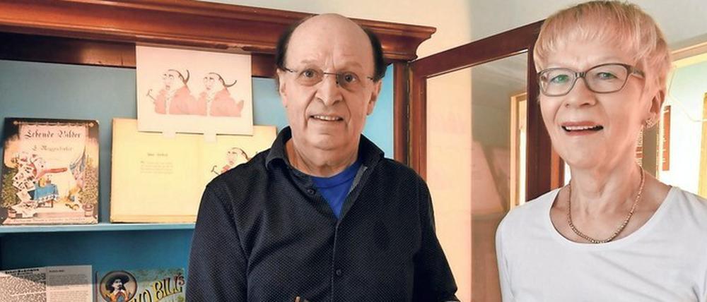 Kuratorin Birgit Jochens und Gestalter Klaus-Dietrich Schulze zeigen das Kinderbuch „Artige Kinder“ von Anna Michaelis.