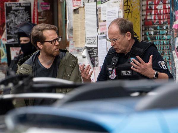 Am Morgen in der Rigaer: Bezirksstadtrat Florian Schmidt (links, Bündnis90/Die Grünen) im Gespräch mit einem Polizisten.