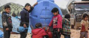 Kinder in einer Notunterkunft in Idlib holen Trinkwasser.