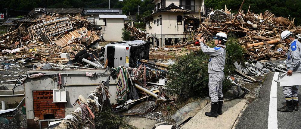 Helfer betrachten das Ausmaß der Verwüstung.
