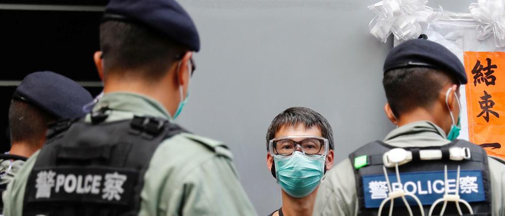 Polizisten und ein Anhänger der Demokratiebewegung in Hongkong