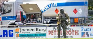 Ein Beamter eines Sondereinsatzkommandos SEK geht über einen Sportplatz nahe der Gemeinde Oppenau, welcher der Polizei als Sammelpunkt dient. 