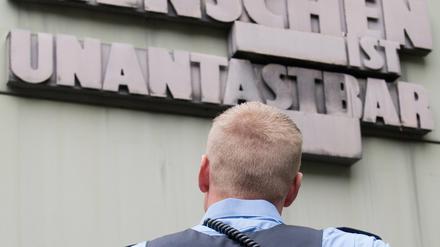 Tägliche Arbeit. Ein Polizist vor Artikel eins des Grundgesetzes.