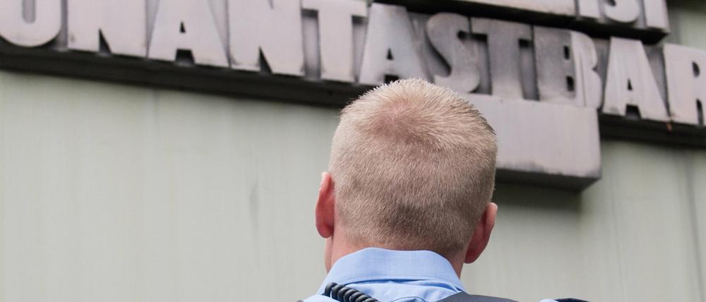 Tägliche Arbeit. Ein Polizist vor Artikel eins des Grundgesetzes.