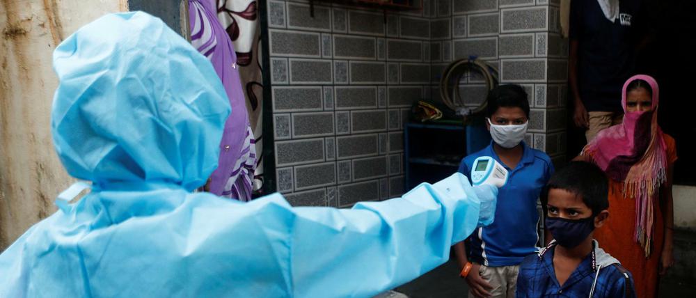 Temperaturmessung. Indische Gesundheitshelferinnen bei einem Einsatz gegen die Verbreitung des Coronavirus in einem Slum in Mumbai.