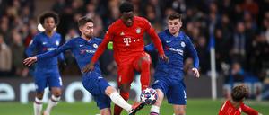 Mittendurch: Alphonso Davies (Mitte) und die Bayern müssen im Achtelfinale der Champions League noch einmal gegen den FC Chelsea ran.
