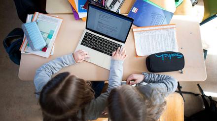 Schüler einer fünften Klasse eines Gymnasiums benutzen im Unterricht einen Laptop