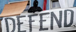 Ein vermummter Mann steht auf einem Balkon eines Hauses in der Rigaer Straße. Die Autonomen werden ihr Hausprojekt auch mit Gewalt verteidigen, kündigten sie an.