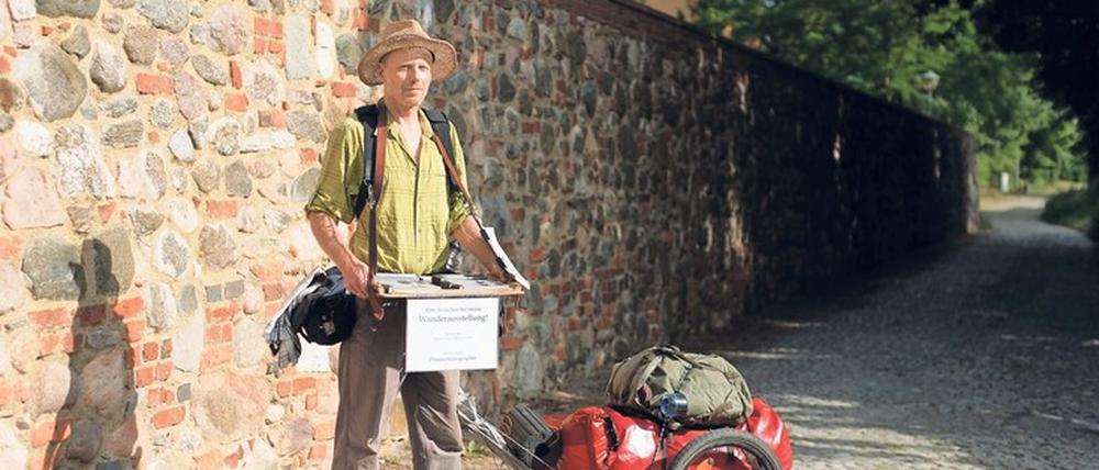 Idealer Corona-Abstand. Seine Daumenkinos trägt Volker Gerling – hier am Brandenburger Kloster Neuzelle zur Halbzeit seiner Tour – auf einem alten Tablett vor sich her.