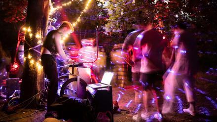 Menschen feiern im Volkspark Hasenheide eine Party. 
