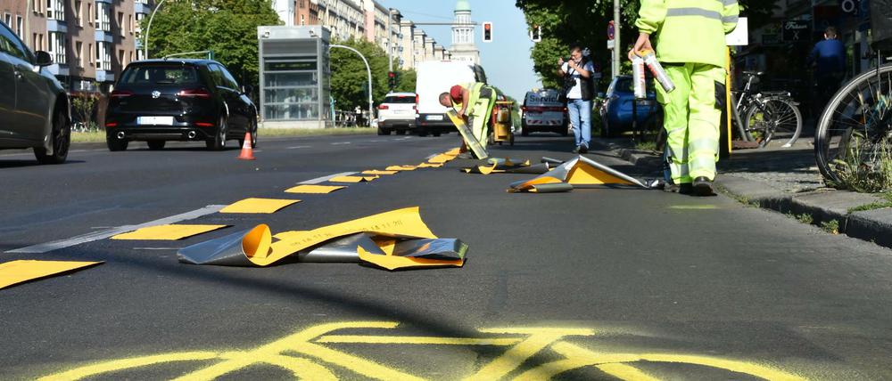 Bauarbeiter richten im Mai einen temporären Radweg auf der Frankfurter Allee ein.