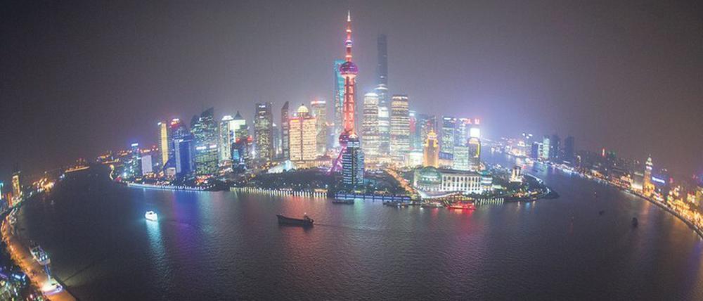 Skyline von Schanghai, hell erleuchtete Wolkenkratzer vor dunklem Himmel