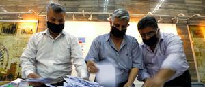 Männer zählen die Stimmzettel am Dienstag.