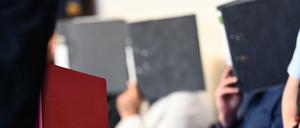 Die elf Angeklagten sitzen vor dem Prozessbeginn im Gerichtssaal im Landgericht Freiburg.