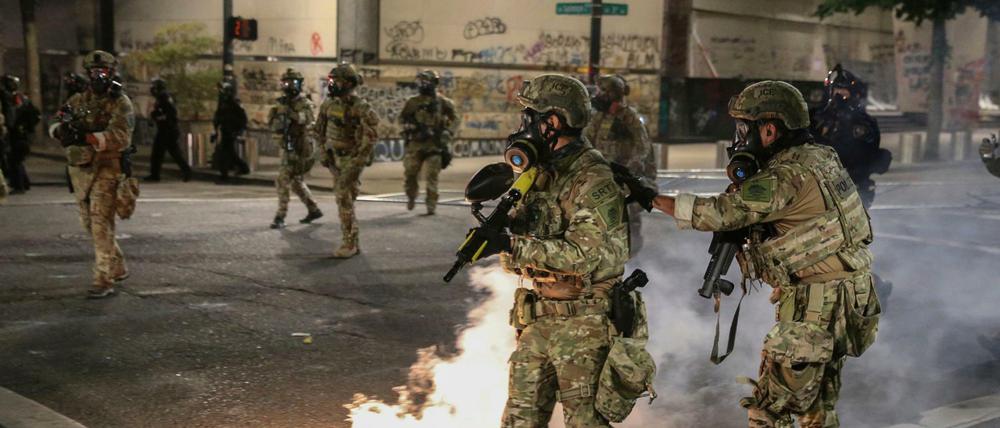 Schwer bewaffnete Sicherheitskräfte in Tarnanzügen gehen in Portland gegen Demonstranten vor. 