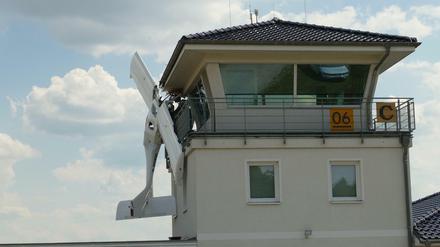 Schwer beschädigt und in sich verdreht hängt das Kleinflugzeug am Tower des Flugplatzes Müncheberg-Eggersdorf.