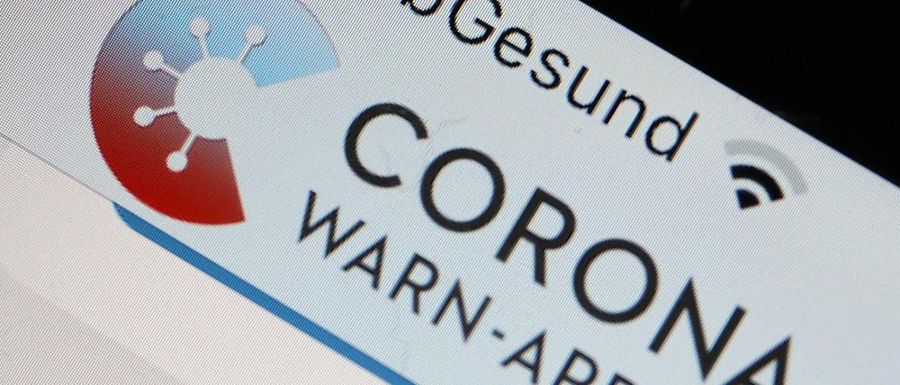 Die Corona-Warn-App mit der Seite zur Risiko-Ermittlung ist im Display eines Smartphone zu sehen.