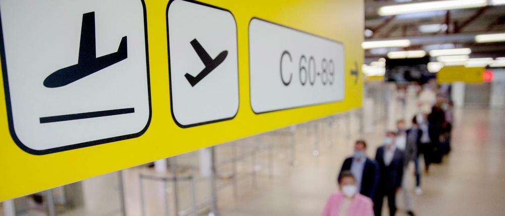 Passagiere stehen am Flughafen Berlin-Tegel vor der Sicherheitskontrolle Schlange.