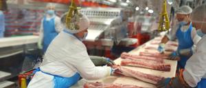 Das von der Firma Tönnies zur Verfügung gestellte Foto zeigt Mitarbeiter, die an ihren Arbeitsplätzen von Plexiglasscheiben voneinander getrennt arbeiten.