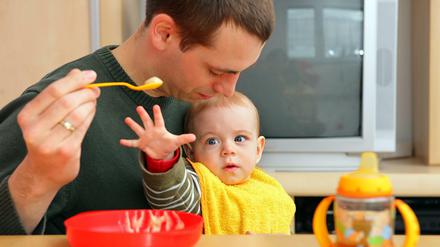 Papa füttert. Väter sind durch die Krise häufiger für ihre Kinder und den Haushalt da. 